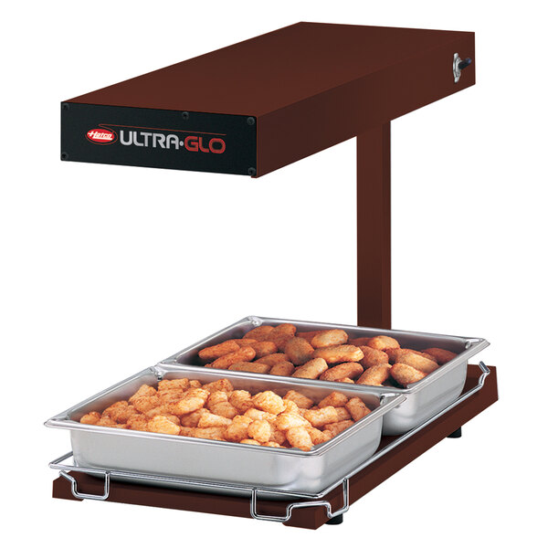 A Hatco Ultra-Glo food warmer on a table with trays of food.