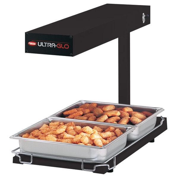 A black Hatco Ultra-Glo food warmer with trays of tater tots.