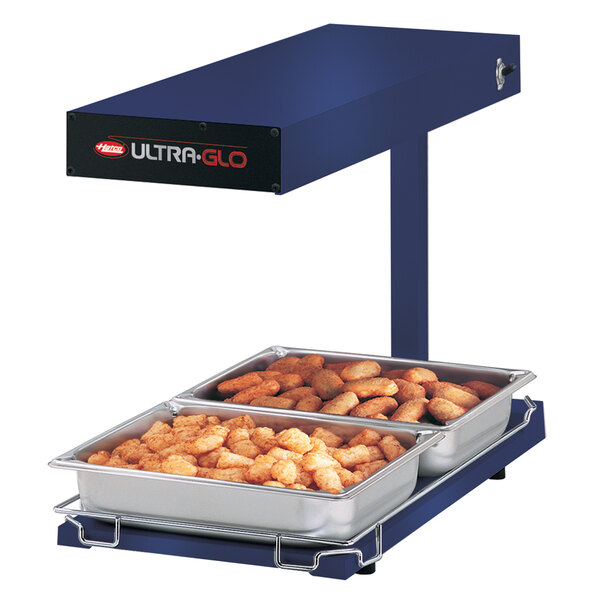 A blue Hatco Ultra-Glo portable food warmer on a table with food in a container.