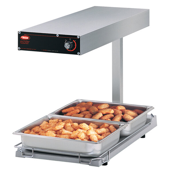 A Hatco portable food warmer on a counter with trays of food in it.