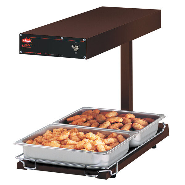 A Hatco heated food warmer on a counter with trays of food in it.