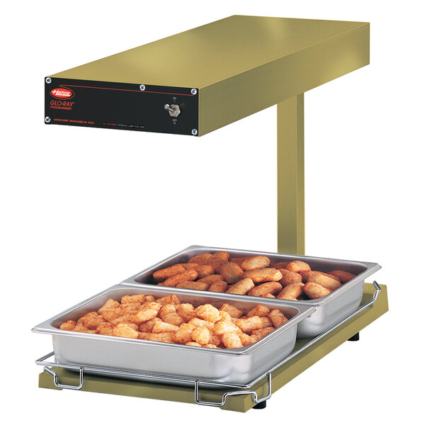 A Hatco portable food warmer with trays of food on it.