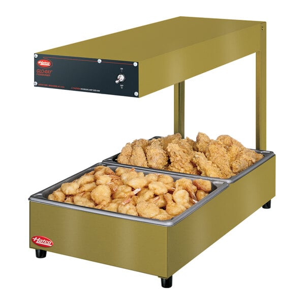 A Hatco Glo-Ray portable food warmer with two trays of chicken and fries.