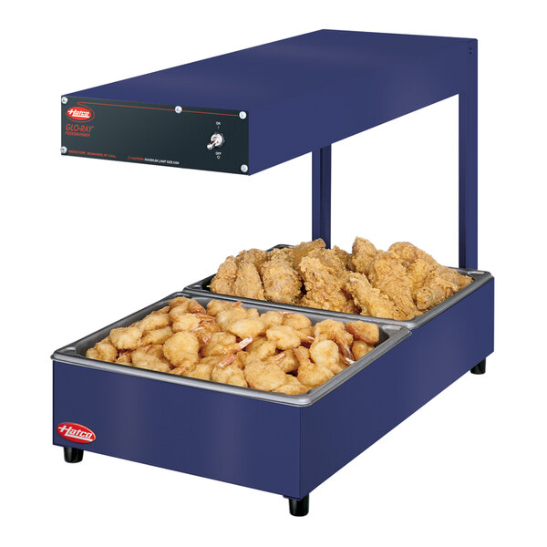 A blue Hatco food warmer with trays of chicken and fries inside.