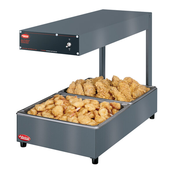 A Hatco portable food warmer with fried chicken in trays.