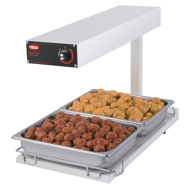 A white Hatco portable food warmer with two trays of food on a heated shelf.