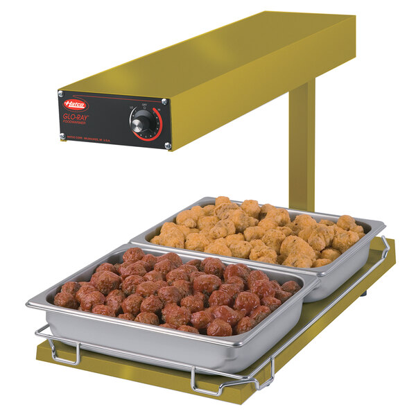 A Hatco portable food warmer with trays of meatballs and chicken on a heated base.