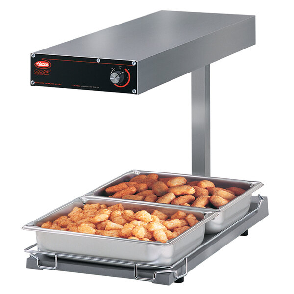 A Hatco portable food warmer on a counter with trays of food inside.