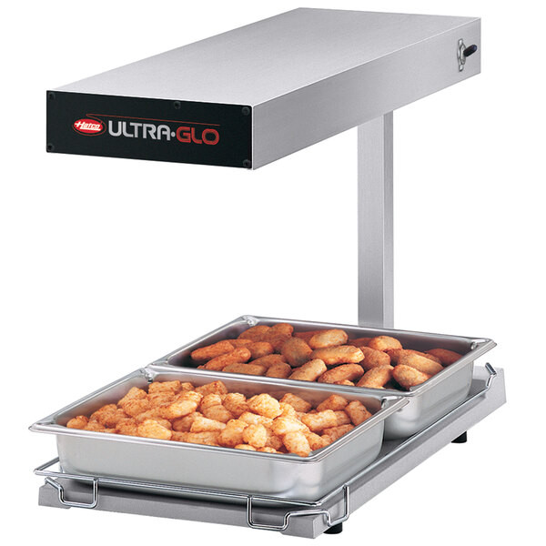 A white Hatco Ultra-Glo food warmer with two trays of food on a counter.