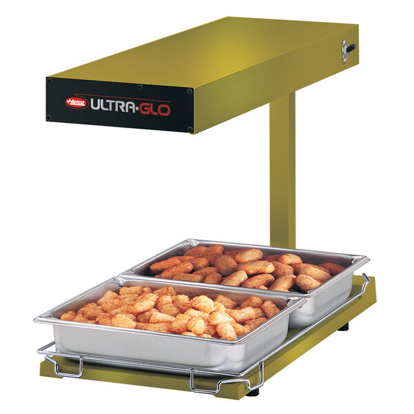 A Hatco Ultra-Glo food warmer with a tray of tater tots on a counter.