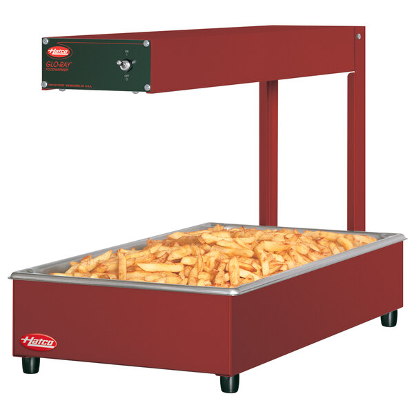 A red Hatco portable food warmer with fries on top.