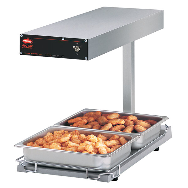 A Hatco Glo-Ray food warmer with trays of food on it.
