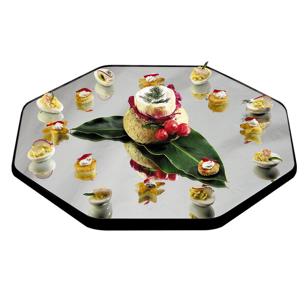 A Geneva octagon mirror food display tray with food on it on a table.