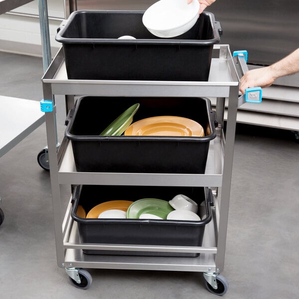 A person putting a white bowl on a Lakeside stainless steel utility cart shelf.