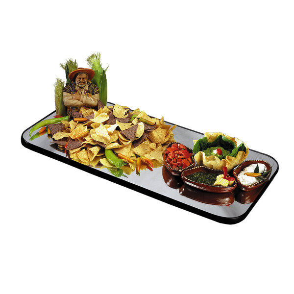 A Geneva rectangular mirror food display tray with bowls of food and a pepper on a table.