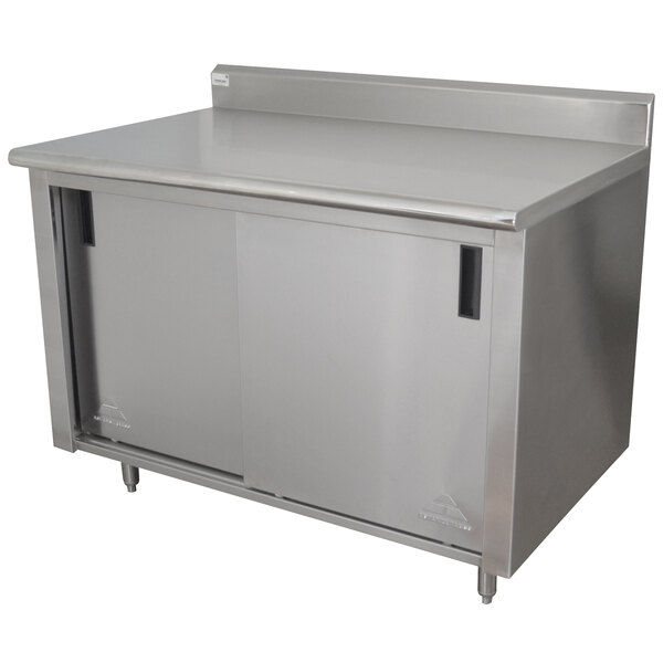 A stainless steel cabinet with doors under a stainless steel work table.