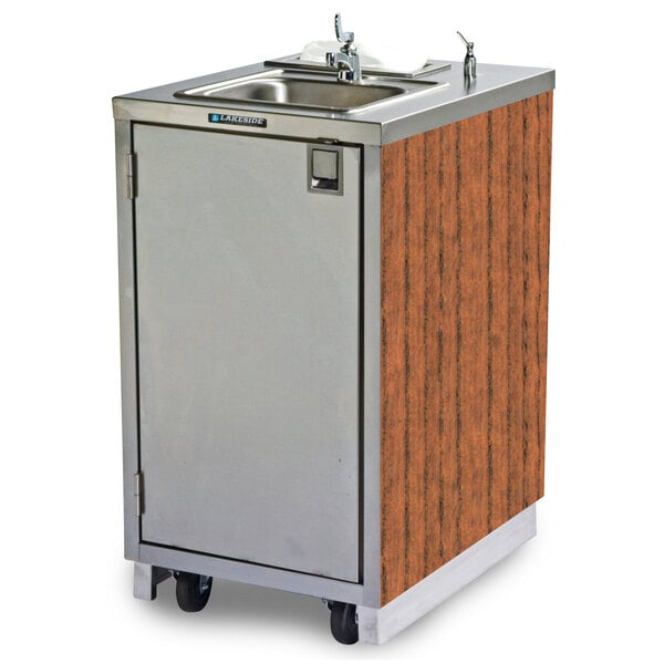 A stainless steel Lakeside portable hand sink with a wooden cabinet.