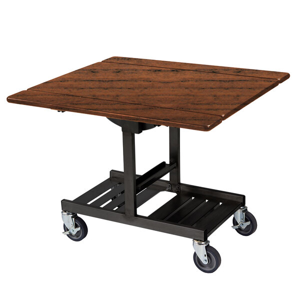A Geneva rectangular room service table with Victorian cherry finish on a black metal cart with wheels.