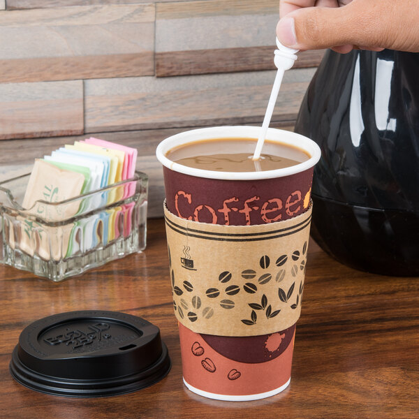 A hand using a Royal Paper Stix To Go white beverage plug and stirrer to stir a coffee cup with a lid.