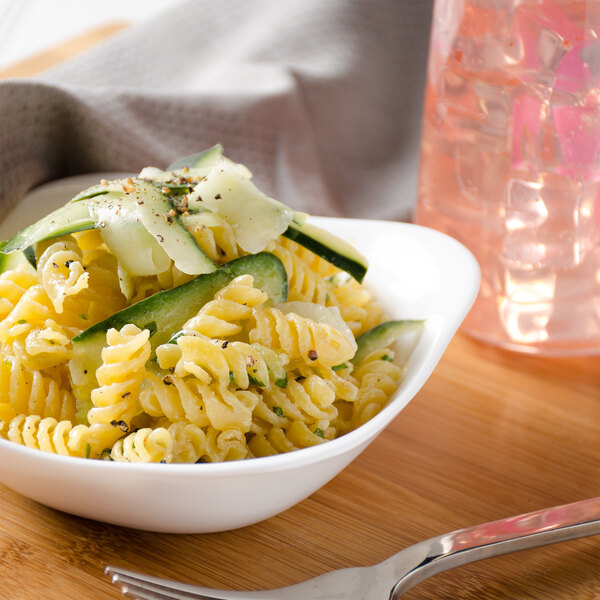 A bowl of Regal rotini pasta on a table with cucumbers.