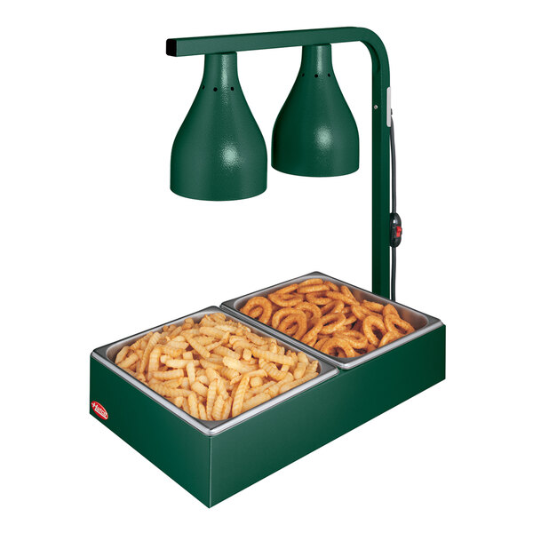 A green Hatco countertop food warmer with two trays of fries inside.