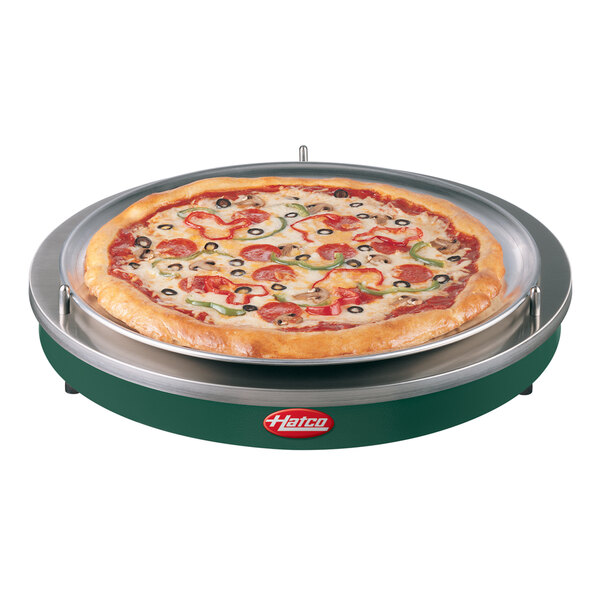 A pizza on a Hatco heated shelf with a green lid.