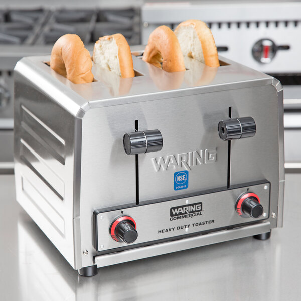 A Waring commercial toaster with bagels in it.
