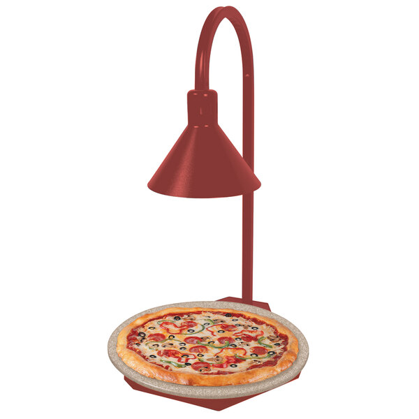 A pizza on a Hatco heated stone shelf with a red display lamp over it.