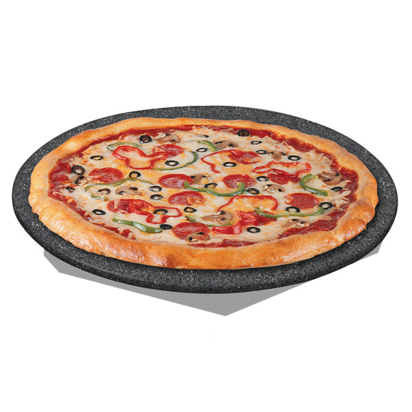 A pizza on a Hatco heated stone shelf with black and white decor.
