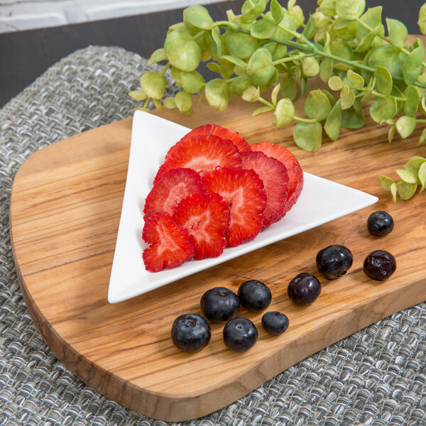 A Whittier white porcelain triangle tid bit tray with strawberries and blueberries on it.