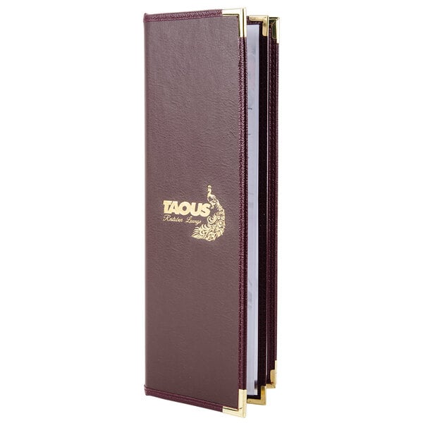 A purple leather-like Menu Solutions booklet cover with gold trim on a table.