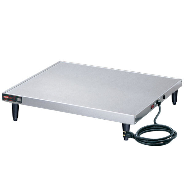 A white rectangular stainless steel Hatco heated shelf warmer on a table with a black power cord.