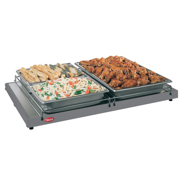 A Hatco portable heated shelf with trays of food on it.