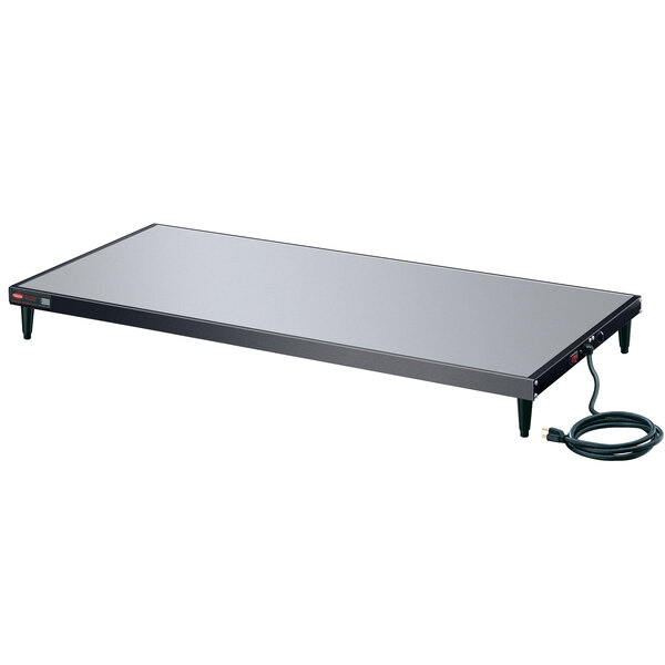 A Hatco Glo-Ray heated shelf with a black rectangular surface and black cord.