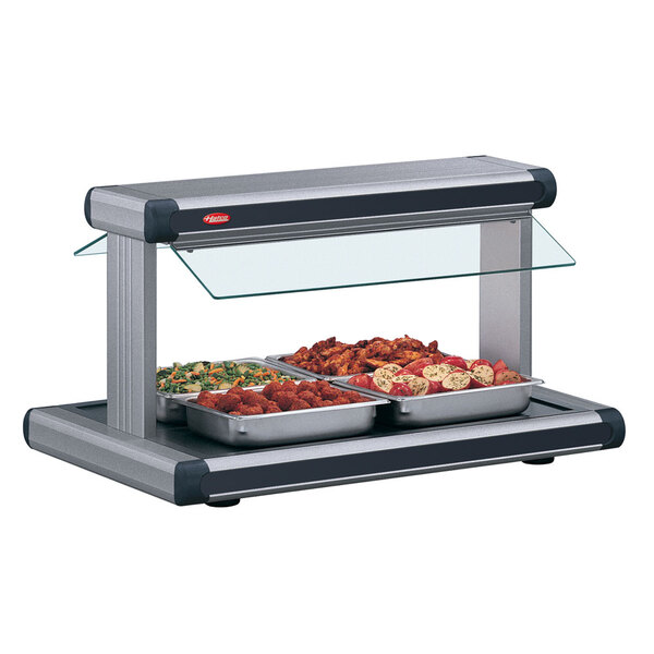 A Hatco buffet warmer with food in black trays on a counter.