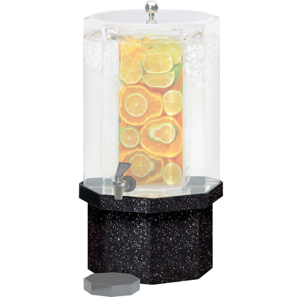 A black octagonal granite charcoal base for a drink dispenser on a counter with fruit slices.