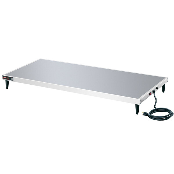 A rectangular white metal Hatco heated shelf on a metal table.