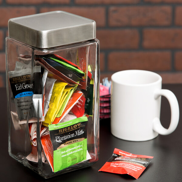 An Anchor Hocking stackable glass jar on a table with tea bags inside.
