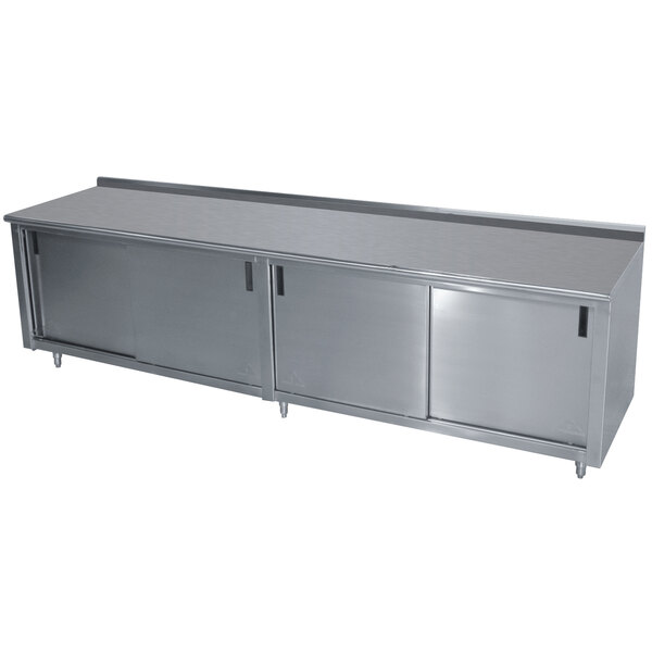 A stainless steel Advance Tabco work table with cabinet base.