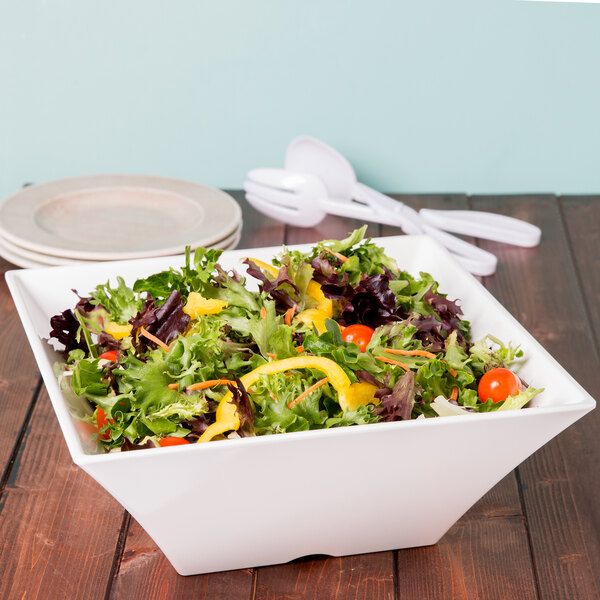 A Tablecraft white melamine square bowl filled with salad on a table.