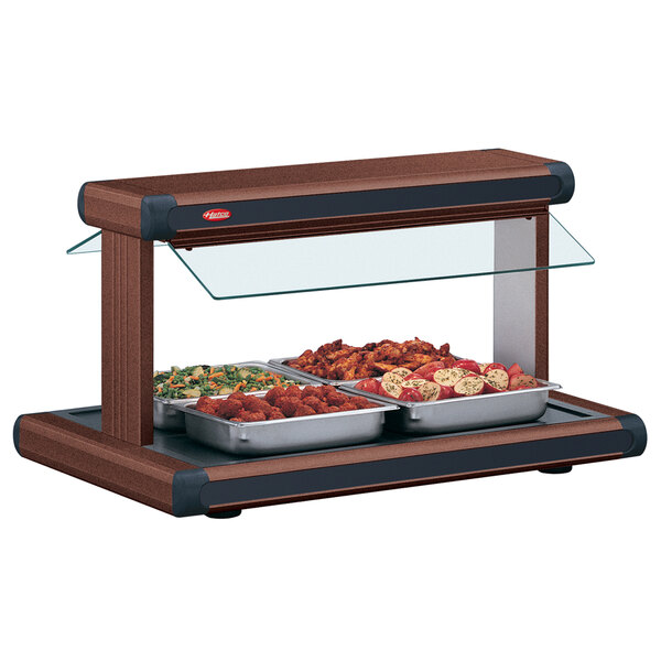 A Hatco buffet warmer with food in black trays on a table.