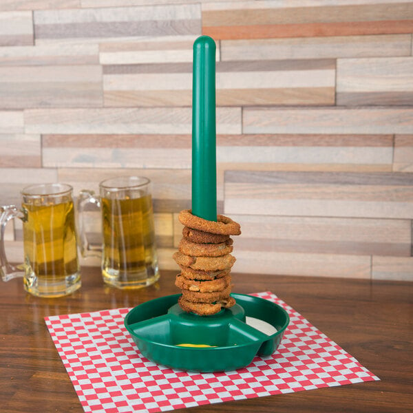 A green container with food rings on a stack of fried food on a table.