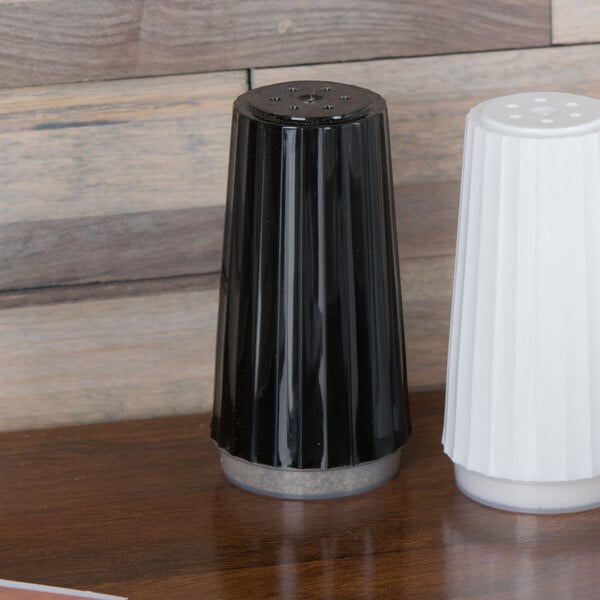 A black and white salt and pepper shaker on a table.