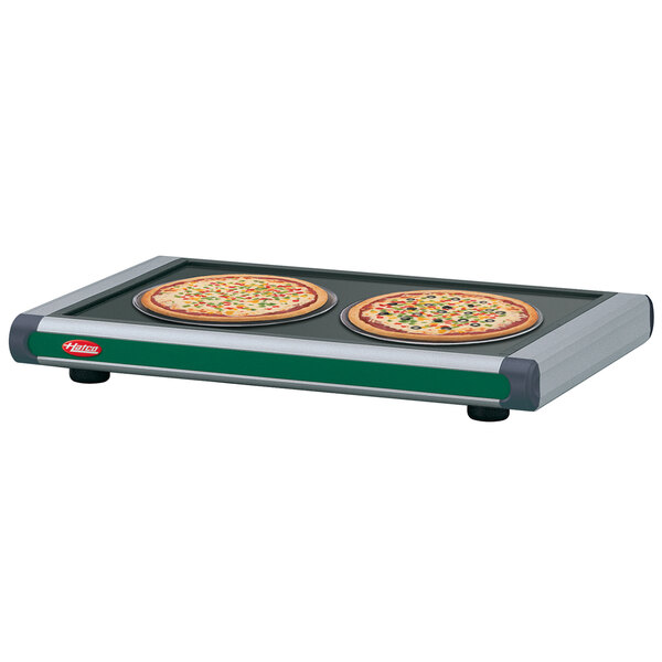 A Hatco heated shelf with two pizzas on it.