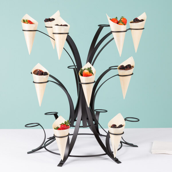 A black Cal-Mil multi-tier cone display stand holding fruit.