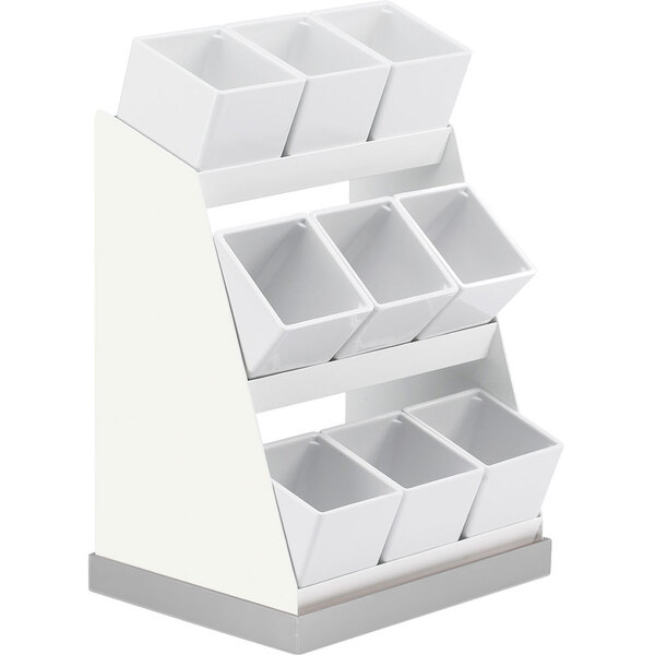 A white display stand with six square compartments holding white melamine jars on a white base.