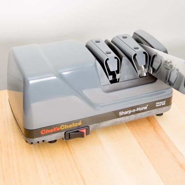 A Edgecraft Chef's Choice 325 knife sharpener on a counter with a knife in it.