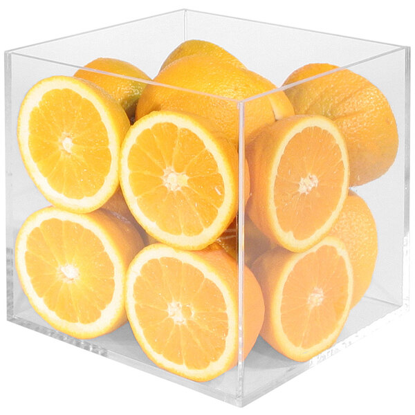 A clear display cube with oranges inside.