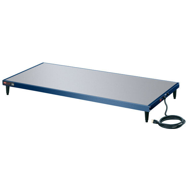 A blue rectangular Hatco heated shelf with a black cord on a table.