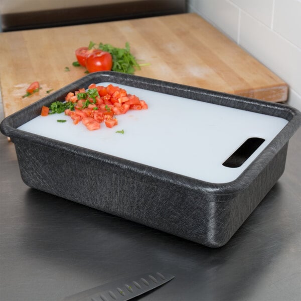 A black HS Inc. charcoal tote with a white cutting board and diced tomatoes on it.